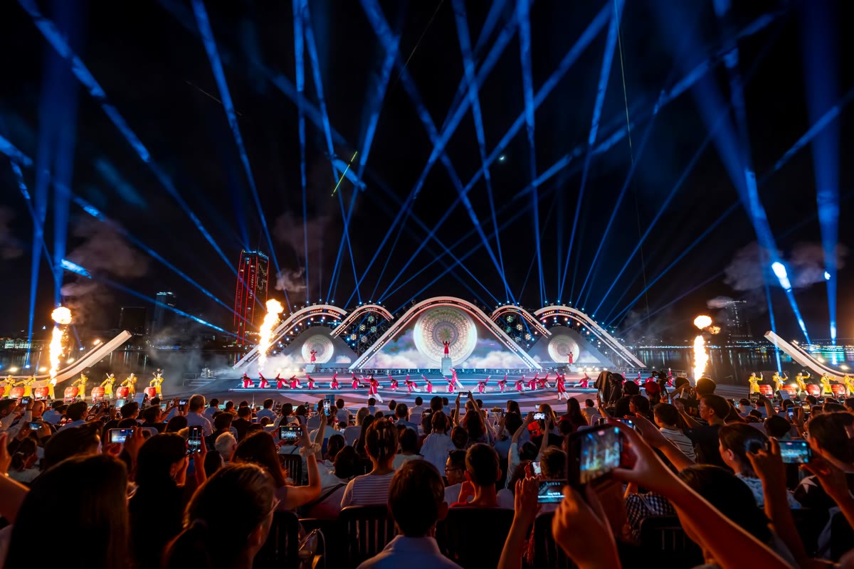 Stage with blue spotlights and the audience filming on their phones